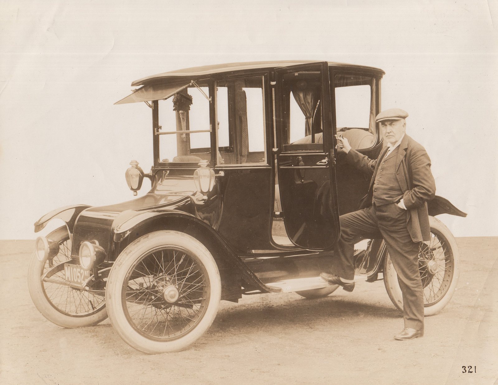 Thomas Edison standing beside a Detroit Electric car in 1913