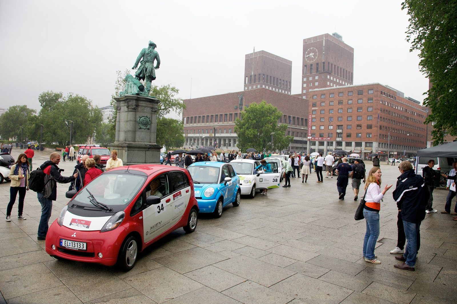 Small electric cars lined up outside Oslo City Hall in 2011, with spectators